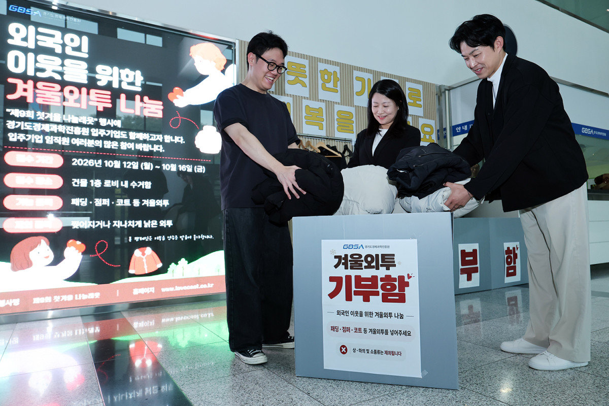 ▲’외국인 이웃을 위한 겨울외투 나눔 캠페인' 참여자들이 경기도경제과학진흥원 건물 1층 로비에 설치된 겨울외투 기부함에 외투를 넣고 있다. (경기도경제과학진흥원)