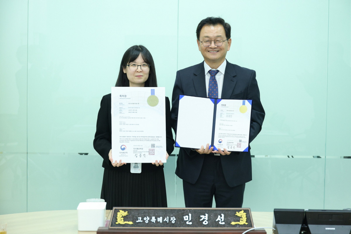 ▲민경선 고양특례시장이 13일 시장 집무실에서 AI 기반 옥외영업 인허가 검증 시스템을 고안한 김동은 주무관과 특허 기념사진을 찍었다. (고양특례시)
