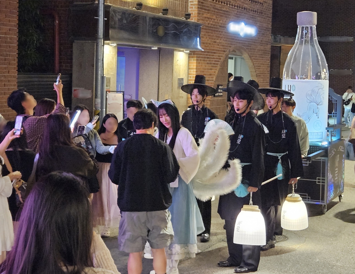 ▲서울 시내 주요 상권에서 ‘새로구미’와 ‘저승사자’로 분장한 새로 행사팀이 거리를 행진하며, 소비자들에게 새로의 신규 광고를 소개한 웹툰 형태의 전단과 구강 청결제를 나눠주고 있다. (사진제공=롯데칠성음료)
