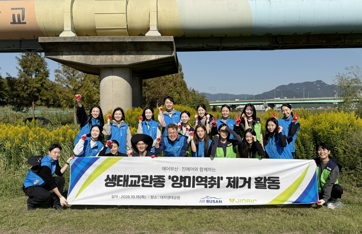 ▲15일 부산 강서구 대저생태공원에서 생태계 교란 식물 제거 활동을 마친 에어부산 및 진에어 임직원들이 기념 촬영을 하고 있다. (사진=에어부산)