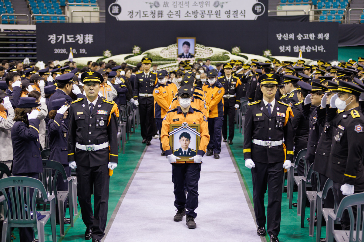 ▲19일 경기 부천체육관에서 엄수된 고(故) 김진석 소방위 영결식에서 고인의 영정을 든 소방대원이 동료들의 경례를 받으며 이동하고 있다. (경기도)