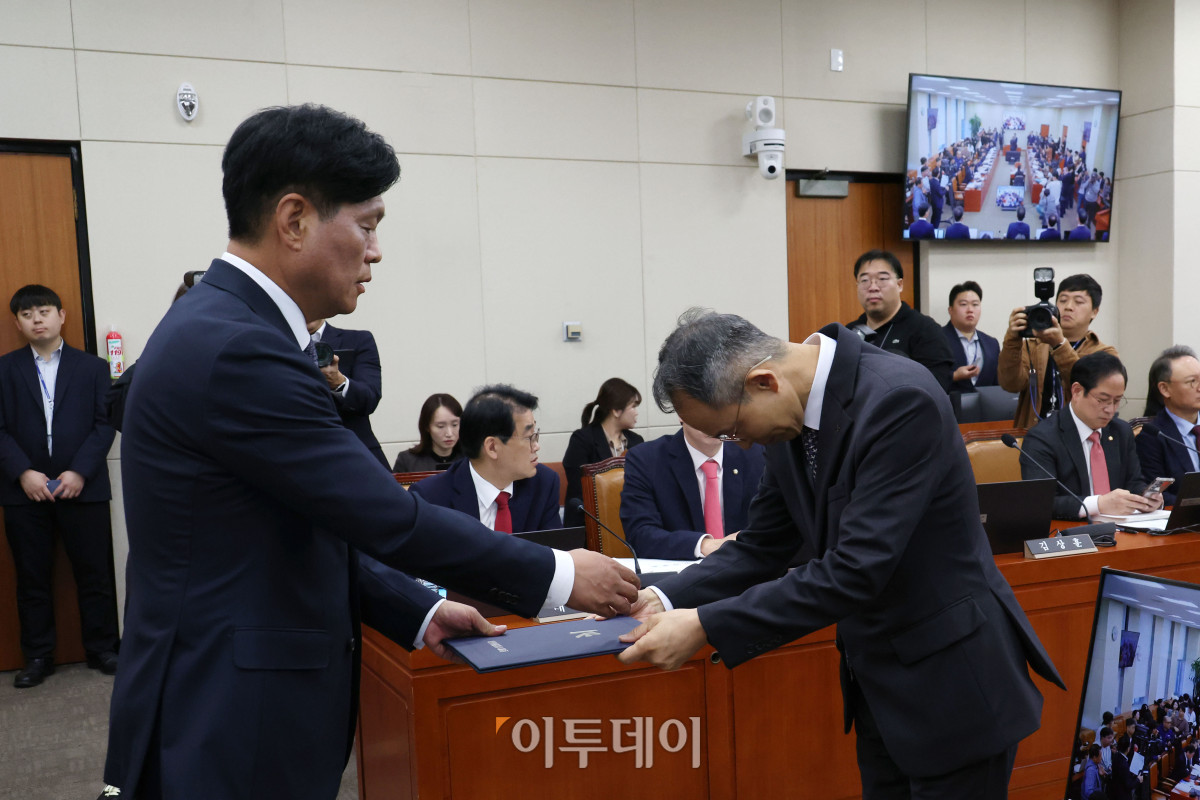 ▲황기연(오른쪽) 한국수출입은행장이 20일 서울 여의도 국회 재정경제기획위원회에서 열린 국정감사에서 증인선서를 마치고 선서문을 더불어민주당 소속 조승래 위원장에게 전달하고 있다. 고이란 기자 photoeran@