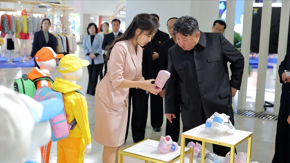 ▲김정은 국무위원장이 19일 '전국피복, 신발전시회-2026'을 찾아 딸 주애가 들어 보이는 분홍색 아동용 운동화를 살펴보고 있다. 조선중앙TV 화면 캡처 (연합뉴스)
