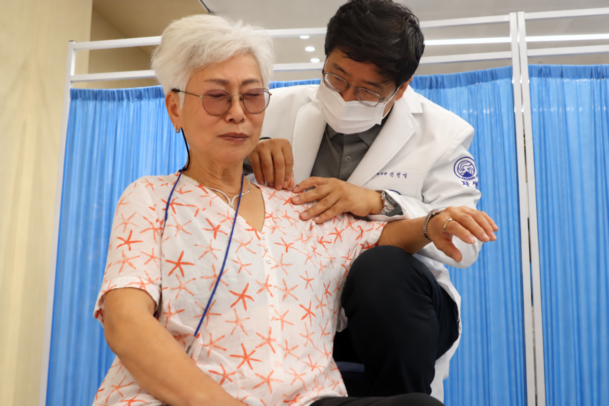 ▲신민식 자생의료재단 사회공헌위원장이 파독 간호사에게 의료봉사를 하고 있다. (자생한방병원)