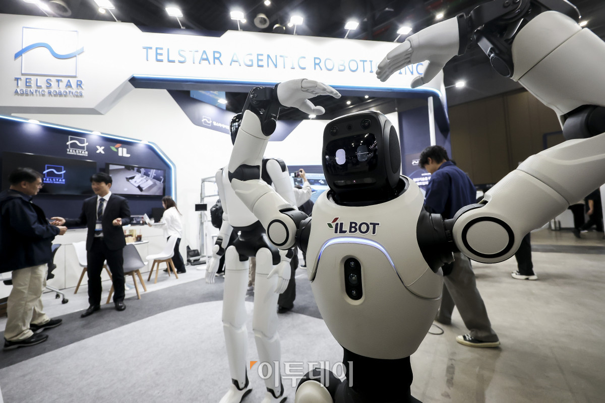 ▲21일 경기 고양시 킨텍스 제1전시장에서 열린 '2026 산업 AI EXPO'를 찾은 관람객들이 텔스타에이전틱로보틱스 부스에서 휴머노이드 로봇이 팔을 올려 하트를 그리고 있다. '2026 산업 AI EXPO'는 산업계 AI 혁신 생태계 구축 및 확산과 산업별 AX 비즈니스 네트워킹 및 협업 파트너십을 구축하기 위해 개최됐다. 행사는 23일까지 킨텍스 제1전시장 2홀에서 열린다. 고성준 기자 joonko1@