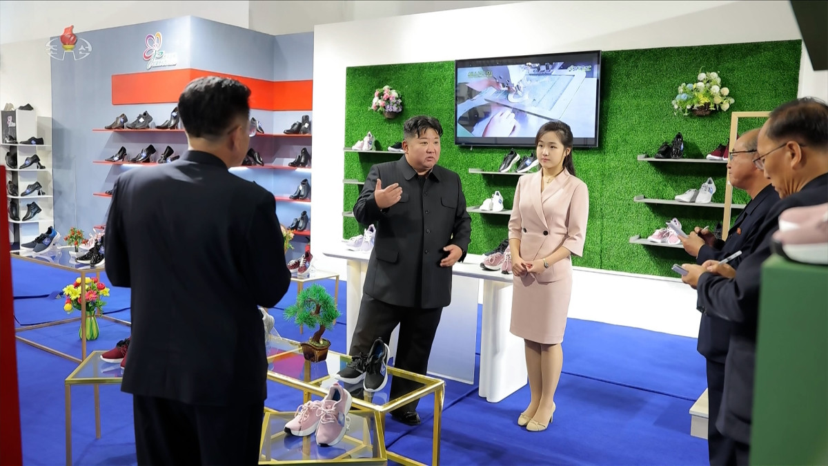▲김정은 북한 국무위원장이 19일 '전국피복, 신발전시회-2026'을 찾아 신발 전시대에서 딸 주애가 지켜보는 가운데 간부들과 이야기하고 있다. (연합뉴스)