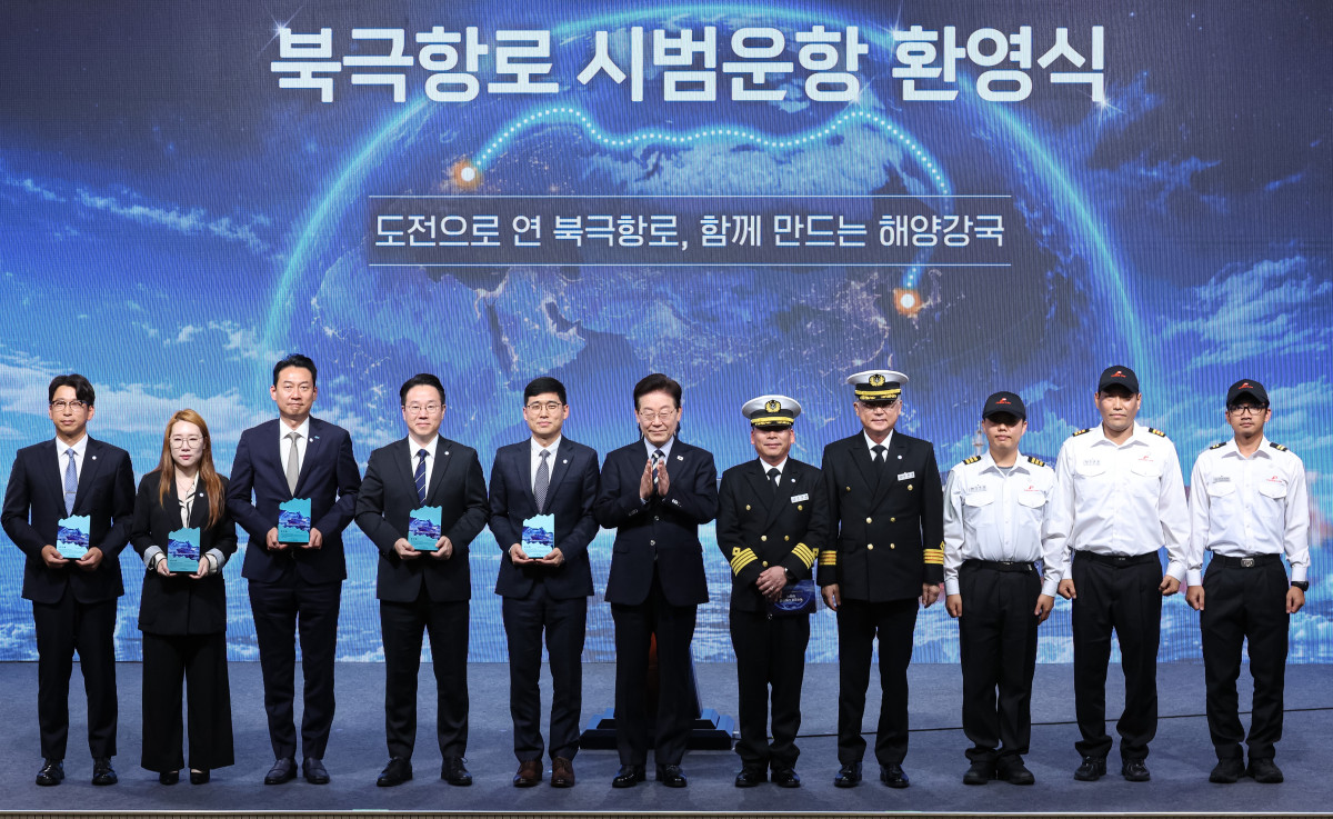 ▲이재명 대통령이 13일 부산에서 열린 북극항로 시범운항 환영식에서 팬스타 아크로호 승선원 및 감사패 수상자들과 기념촬영을 하고 있다. (연합뉴스)