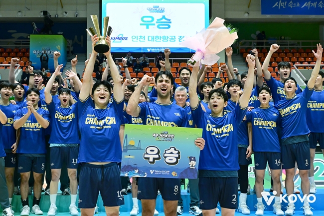 ▲대한항공 선수단이 25일 전남광주통합특별시 여수시 진남체육관에서 열린 2026 여수·NH농협컵 프로배구대회 현대캐피탈과의 결승에서 2연패에 성공, 우승한 뒤 트로피를 들어올리고 있다. (사진제공=한국배구연맹)