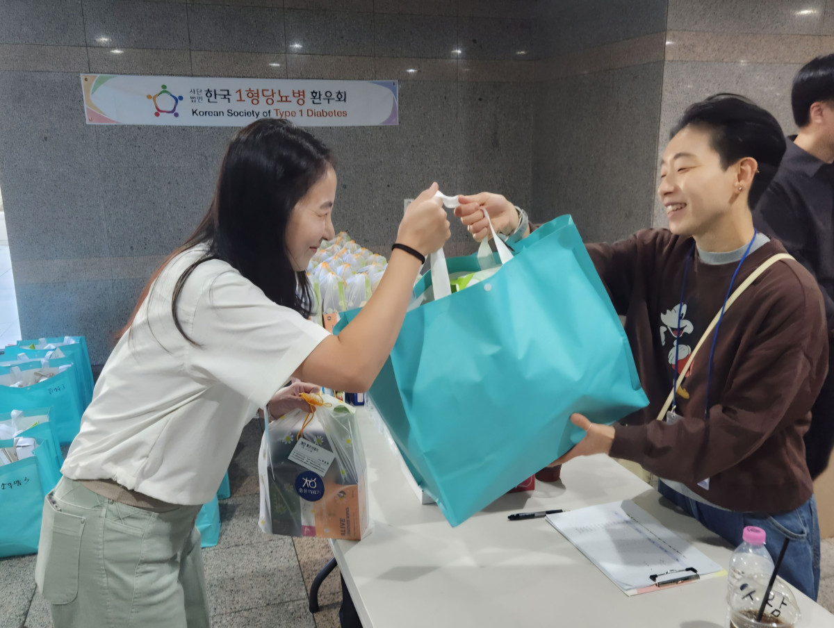 ▲롯데웰푸드 직원이 한국1형당뇨병환우회 하반기 환우모임에서 무설탕 디저트 브랜드 '제로(ZERO)' 제품이 들어있는 가방을 전달하고 있다. (사진제공=롯데웰푸드)