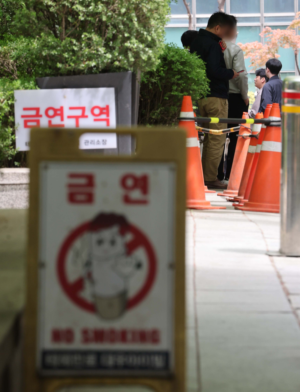 ▲테헤란로 금연거리 시행을 하루 앞둔 지난 4월 22일 서울 강남구 테헤란로 인근 골목의 '금연구역' 푯말 옆에서 흡연자들이 담배를 피우고 있다. (이투데이DB)