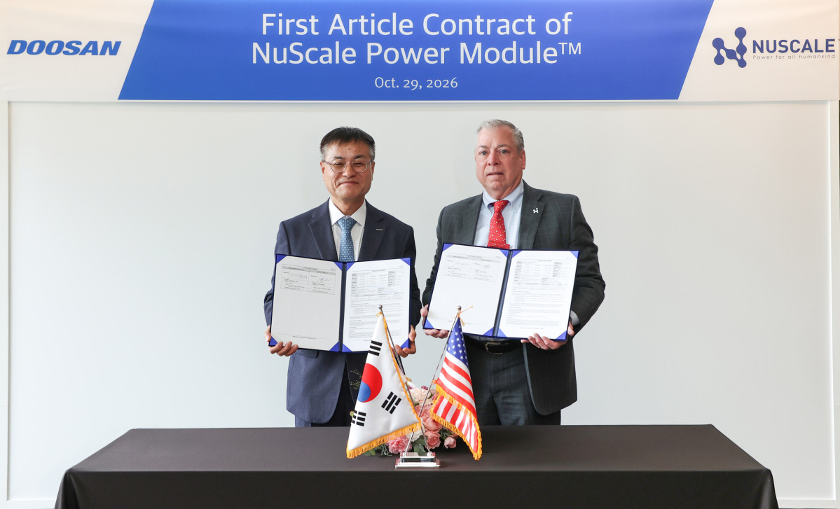 ▲29일 창원 본사에서 열린 계약 체결식에서 뉴스케일파워 칼 피셔 COO(사진 오른쪽)와 두산에너빌리티 김종두 사장이 기념 촬영하고 있다. (두산에너빌리티)