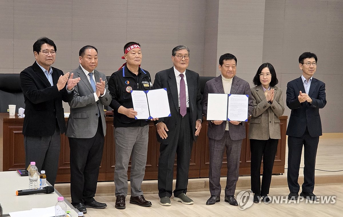▲경기지역 버스 노사 관계자들이 30일 새벽 수원 영통구 경기지방노동위원회에서 임금·단체협약 조정안에 합의한 뒤 기념촬영을 하고 있다. 노사는 시급 3.2% 인상에 합의했지만 서울 버스와의 동일임금 적용 문제는 추후 논의하기로 했다. (연합뉴스)